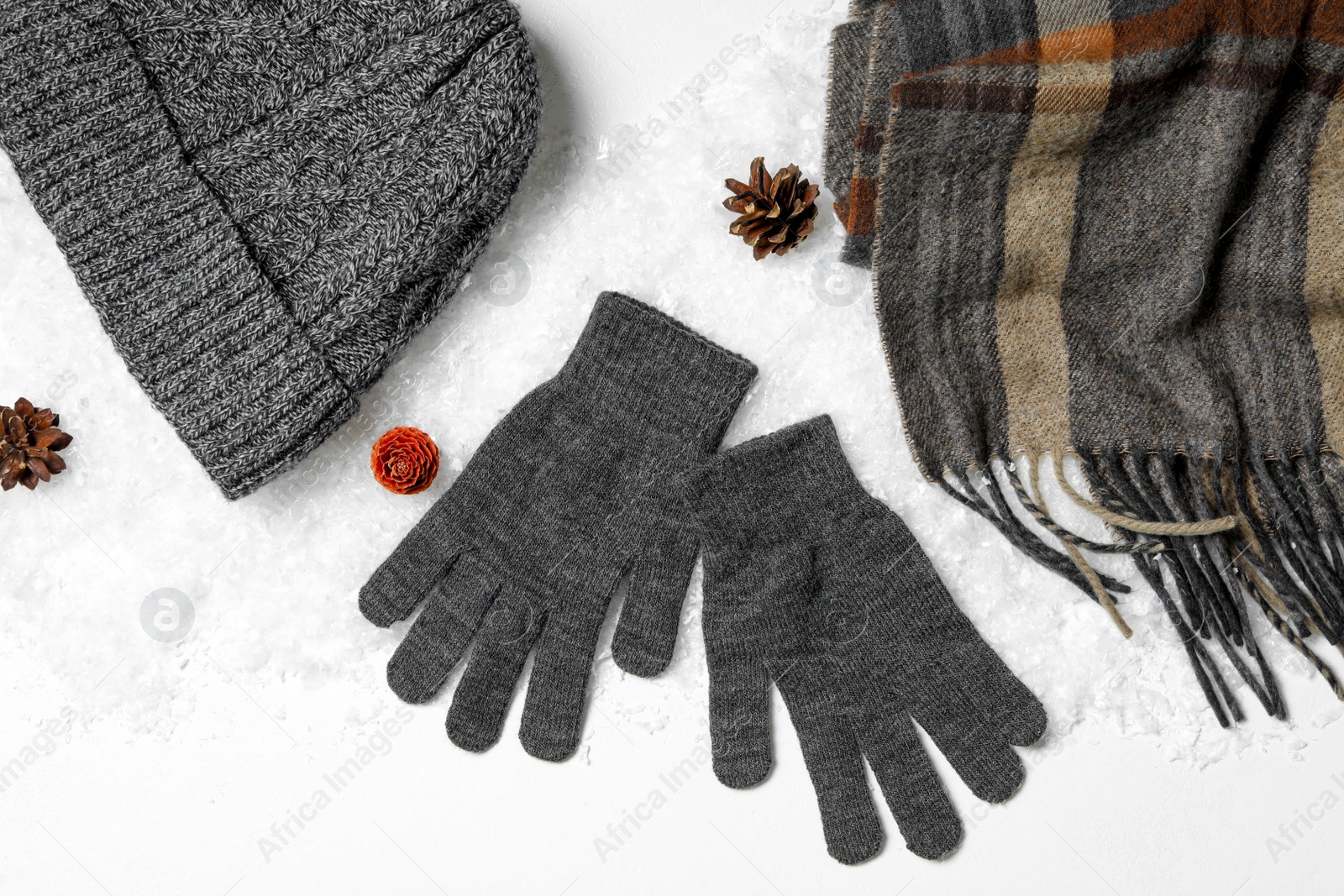 Photo of Stylish grey woolen gloves, scarf and hat on white background, top view