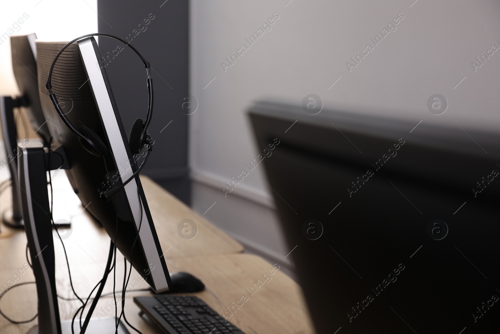 Photo of Modern computer with headset in office. Hotline service