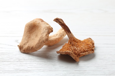 Photo of Dried mushrooms on white wooden background, closeup