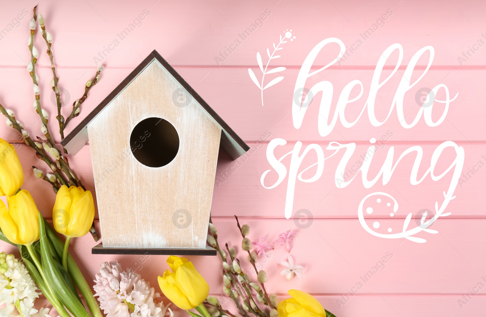 Image of Hello Spring. Flat lay composition with bird house and flowers on pink wooden background 