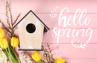 Image of Hello Spring. Flat lay composition with bird house and flowers on pink wooden background 