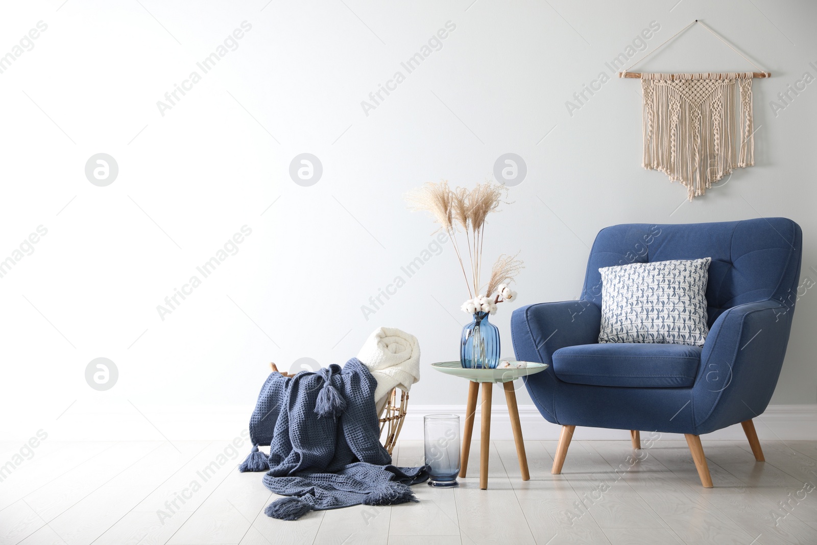 Photo of Basket with soft plaids in living room interior