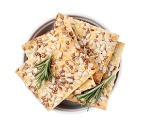 Cereal crackers with flax, sunflower, sesame seeds and rosemary in bowl isolated on white, top view