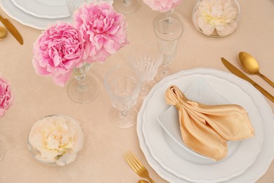 Photo of Stylish table setting with beautiful peonies and fabric napkin