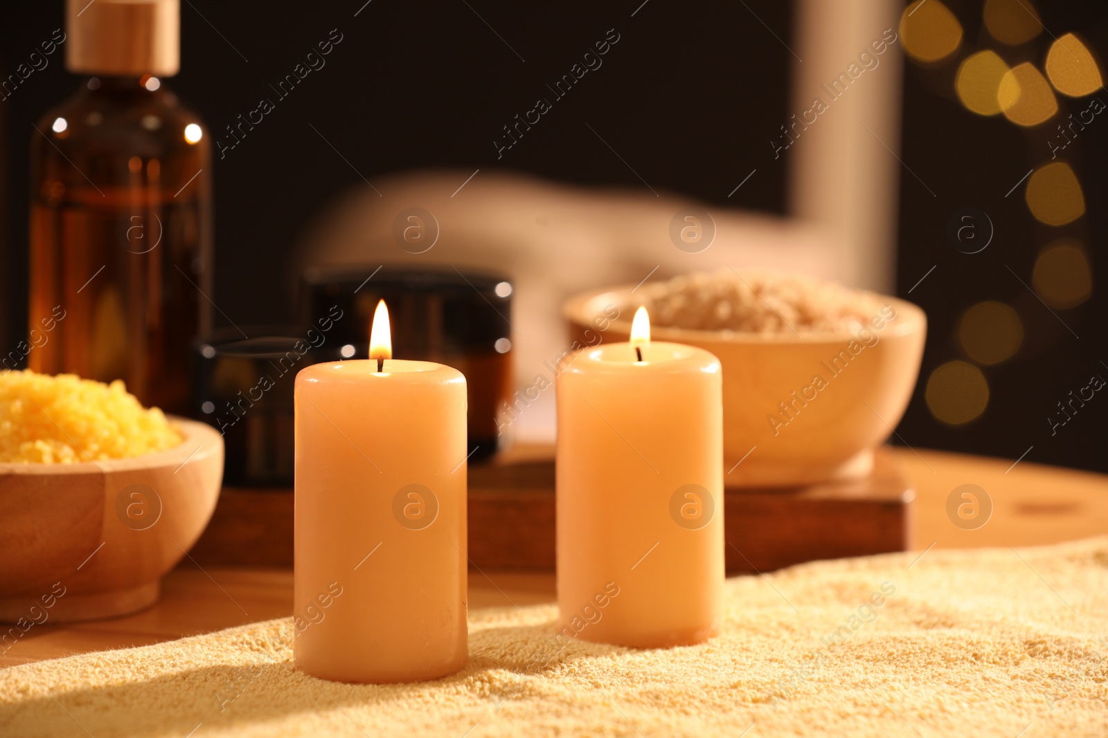 Photo of Spa composition with burning candles and personal care products on soft light surface, closeup