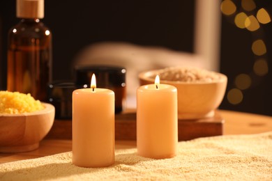 Photo of Spa composition with burning candles and personal care products on soft light surface, closeup