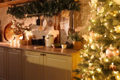 Stylish kitchen with festive decor and Christmas tree. Interior design