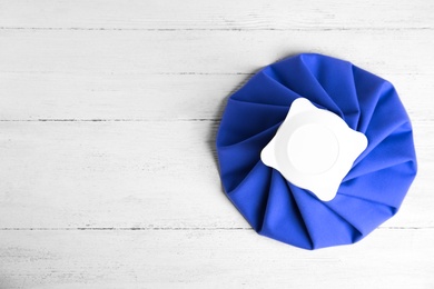 Ice pack on white wooden table, top view. Space for text