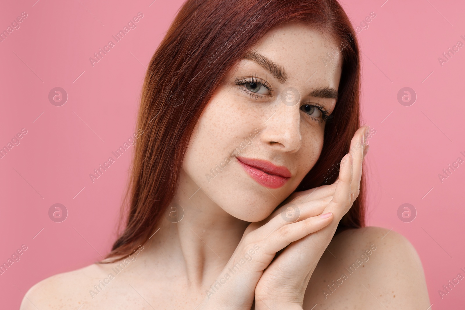 Photo of Portrait of beautiful woman with freckles on pink background, closeup