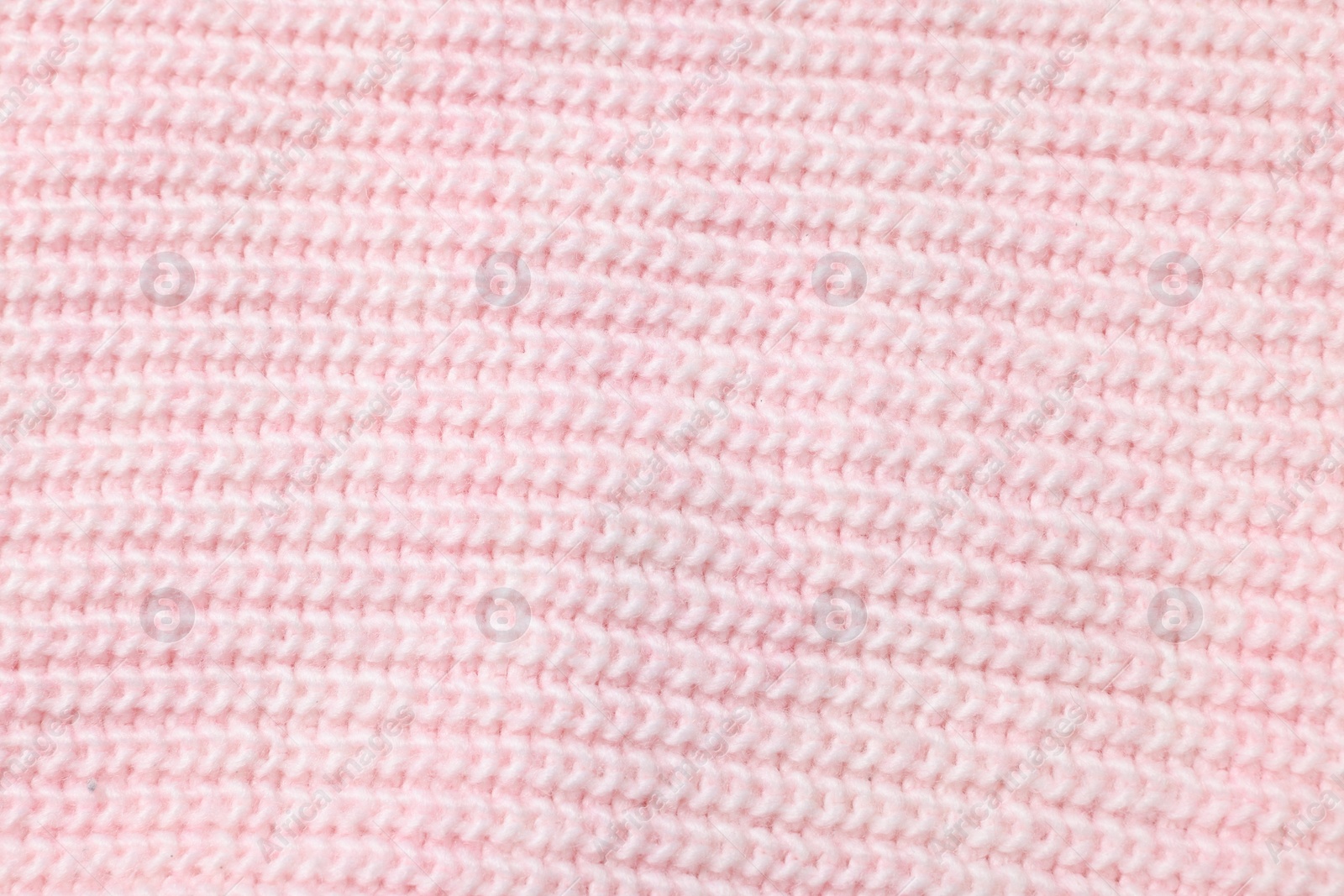 Photo of Texture of soft pink knitted fabric as background, top view