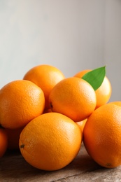 Photo of Fresh oranges with leaves on wooden table