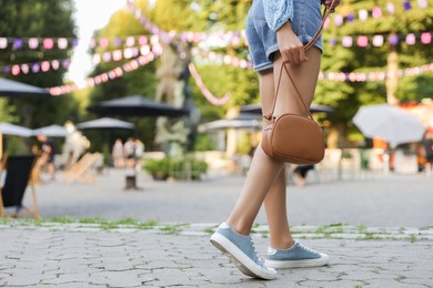 Photo of Woman with stylish bag outdoors, closeup. Space for text
