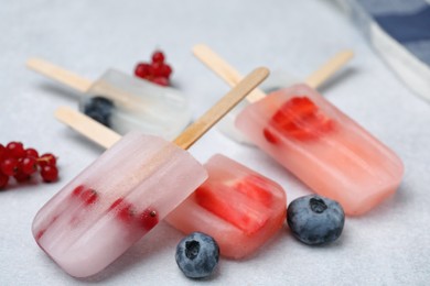 Photo of Tasty berry ice pops on light table, closeup