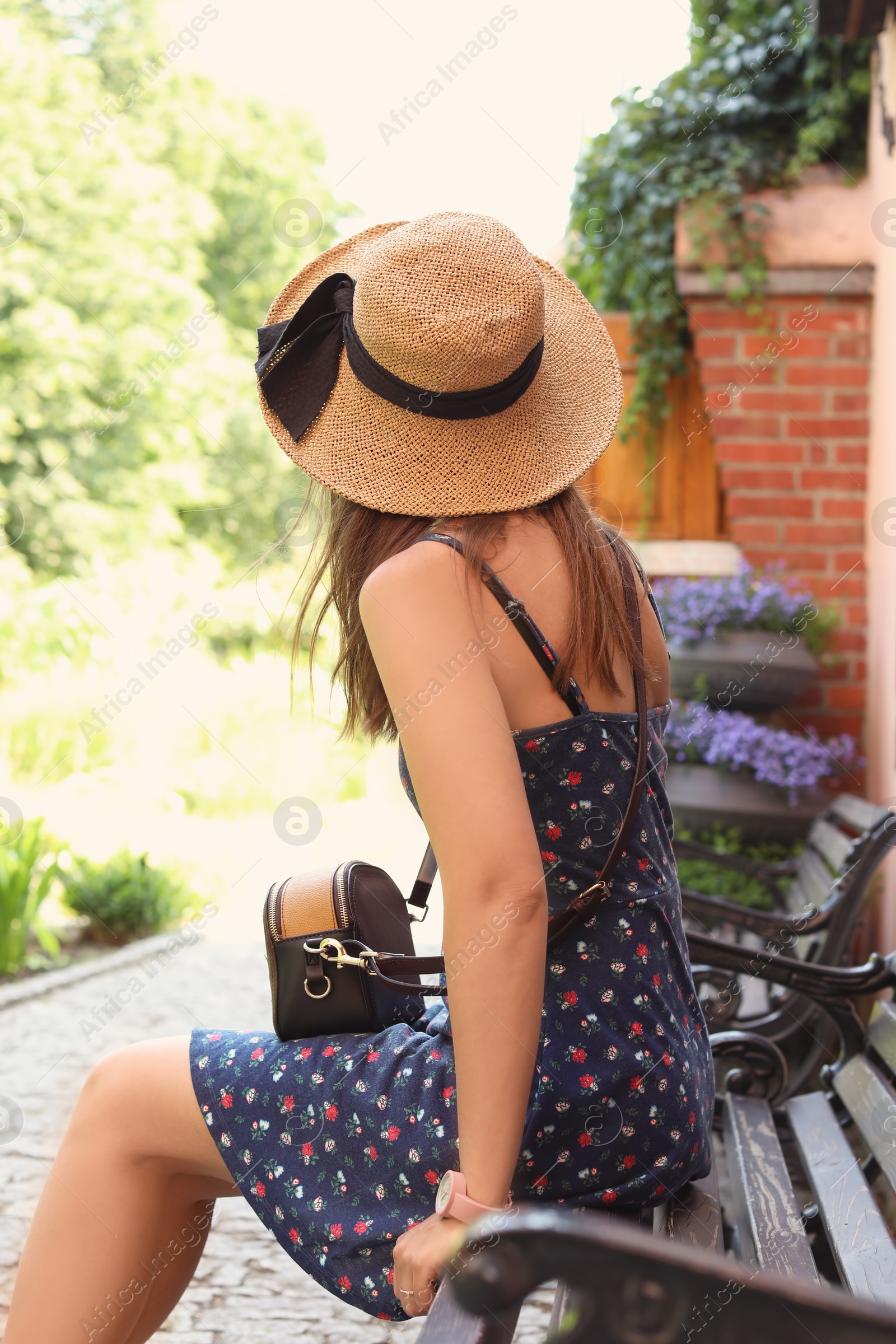 Photo of Young woman resting on wooden bench outdoors