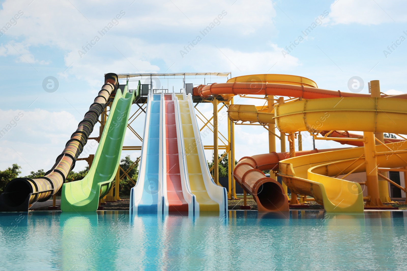 Photo of Beautiful view of water park with colorful slides and swimming pool on sunny day