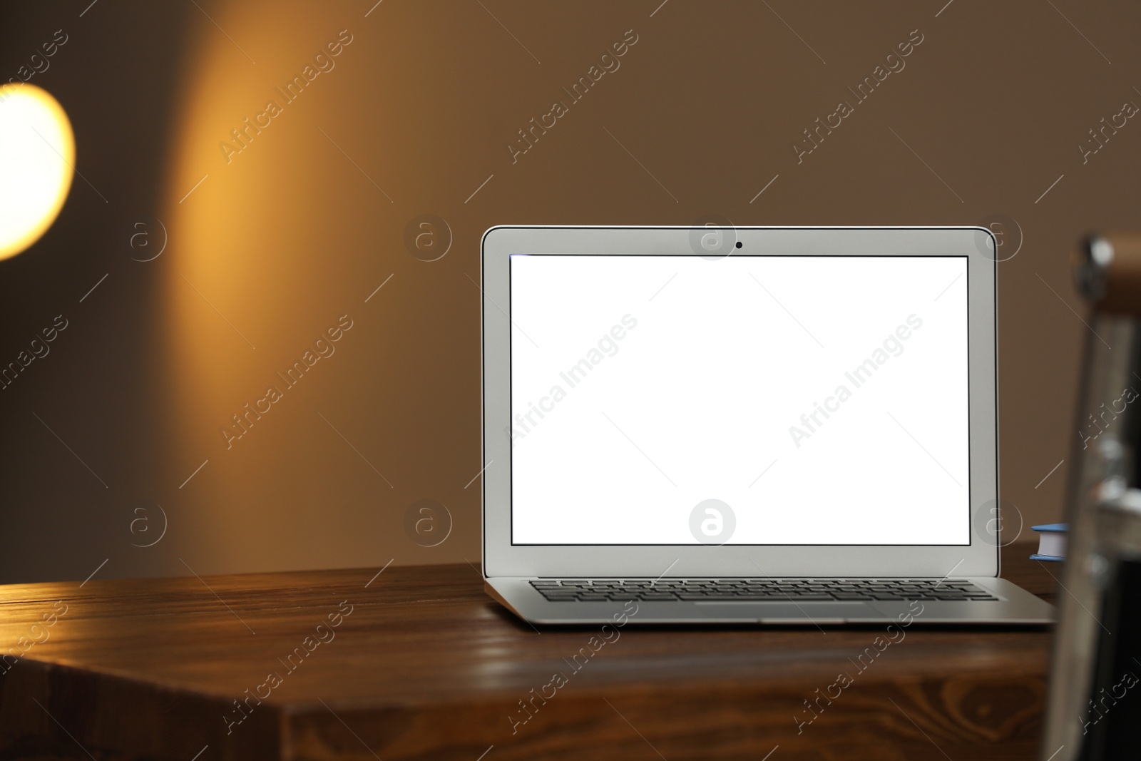 Photo of Laptop with blank screen on table indoors. Space for text