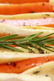 Photo of Slices of parsnip and carrot with rosemary, closeup