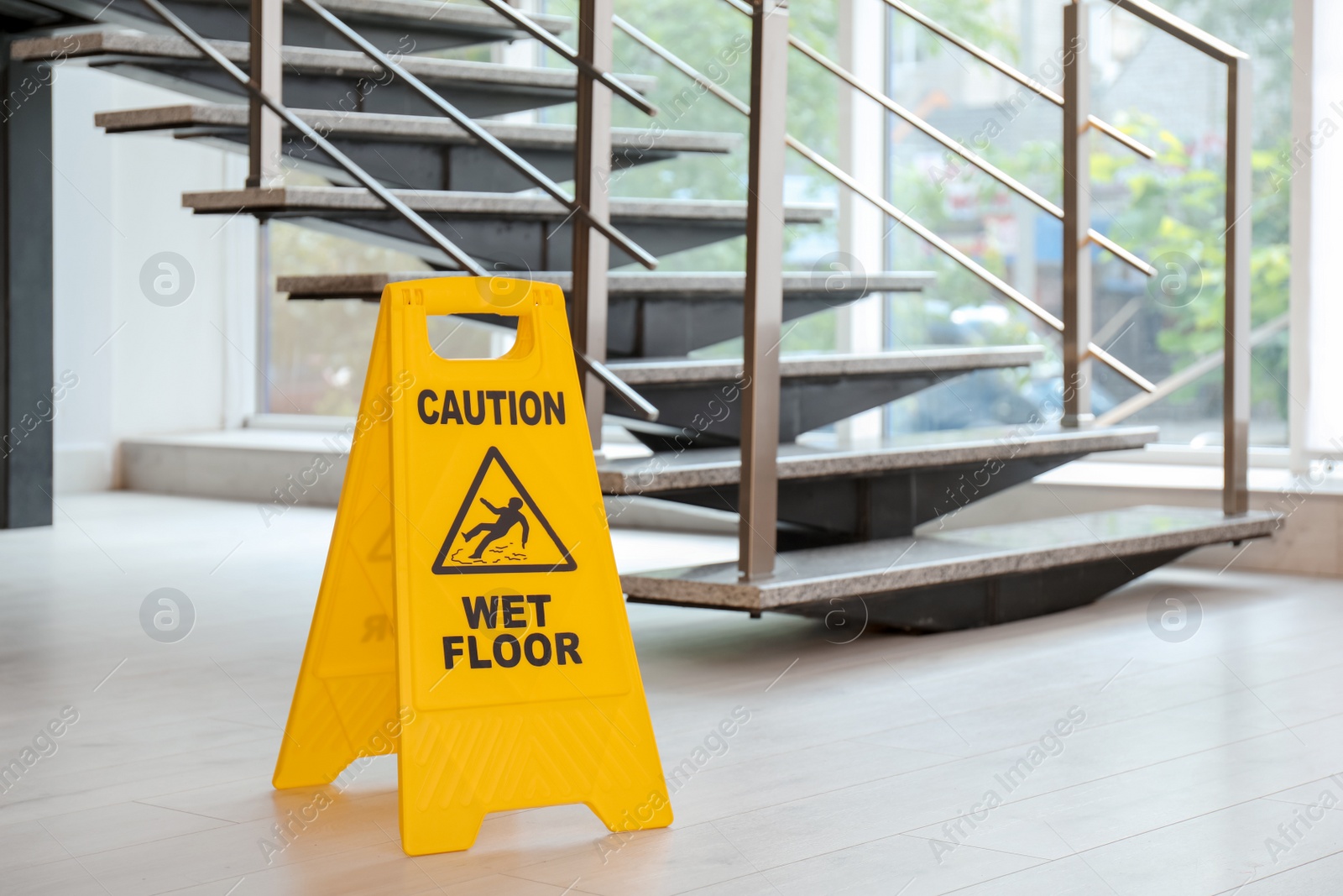 Photo of Safety sign with phrase Caution wet floor near stairs. Cleaning service