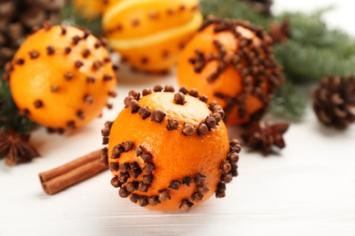 Pomander balls made of fresh tangerines with cloves on white wooden table. Christmas atmosphere