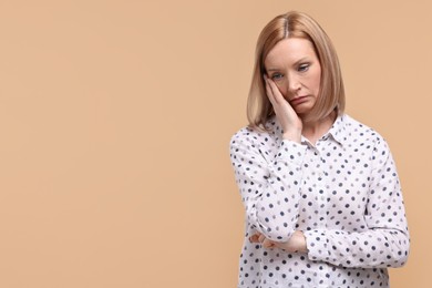 Photo of Portrait of sad woman on beige background. Space for text