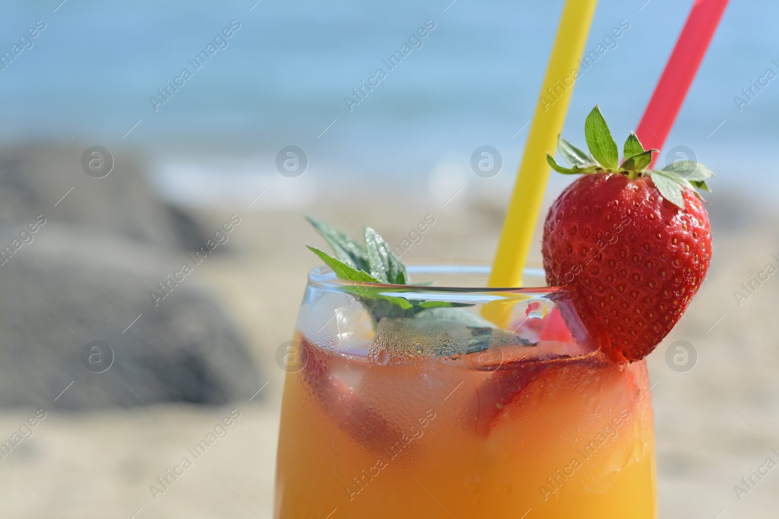 Photo of Glass of refreshing drink with strawberry and mint near sea, closeup. Space for text