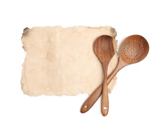 Old cookbook page and wooden utensils on white background, top view. Space for text