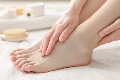 Closeup view of woman`s groomed feet after care procedure on soft towel