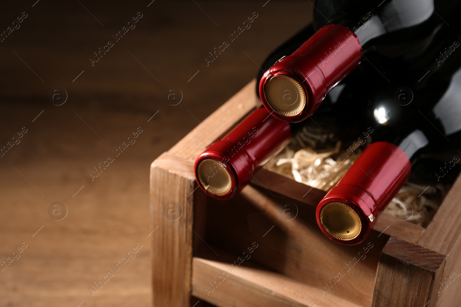 Photo of Wooden crate with bottles of wine on table. Space for text