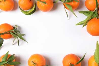 Photo of Frame made of ripe tangerines on white background, top view. Space for text