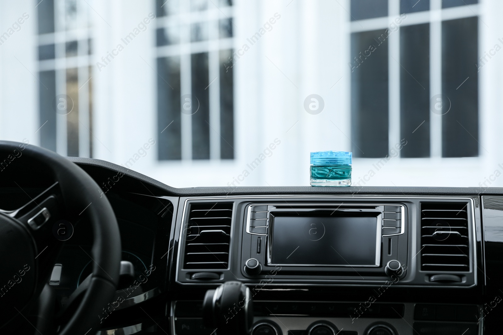 Photo of Stylish air freshener on dashboard in car