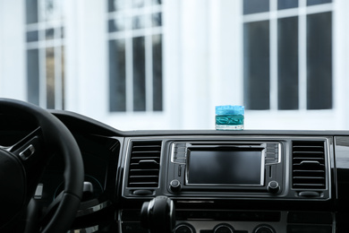 Stylish air freshener on dashboard in car