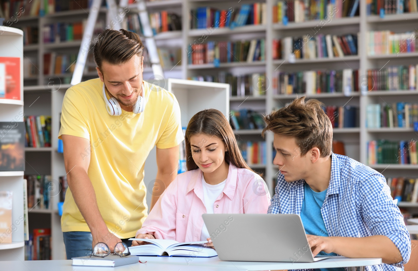 Photo of Group of young people studying at table in library