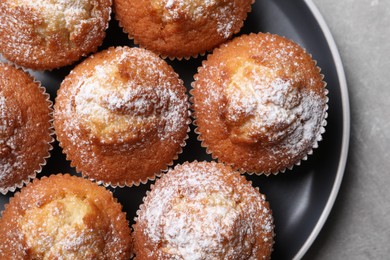 Delicious sweet muffins on grey textured table, top view