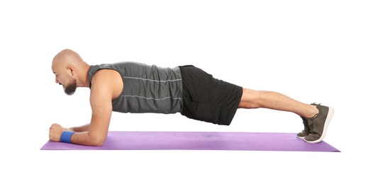 Photo of Overweight man doing plank exercise on white background