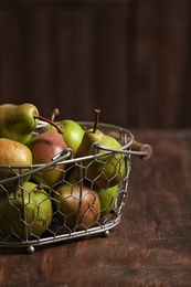 Photo of Basket with ripe pears on wooden table