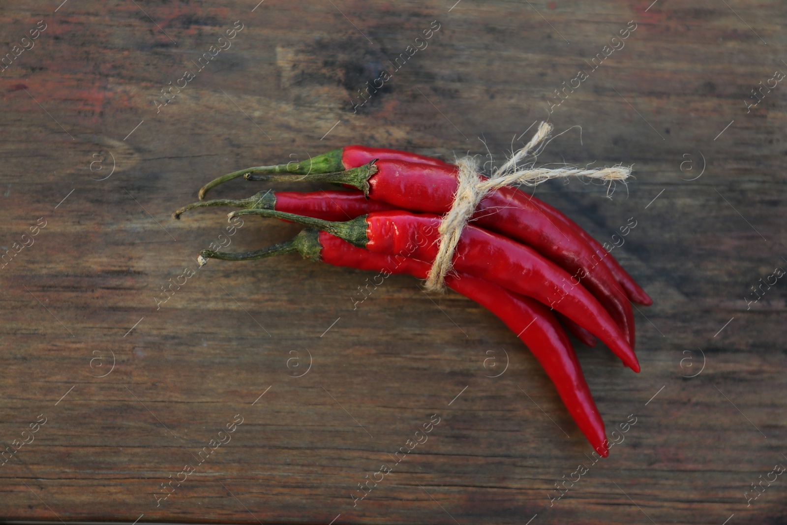 Photo of Fresh ripe chili peppers on wooden table, flat lay