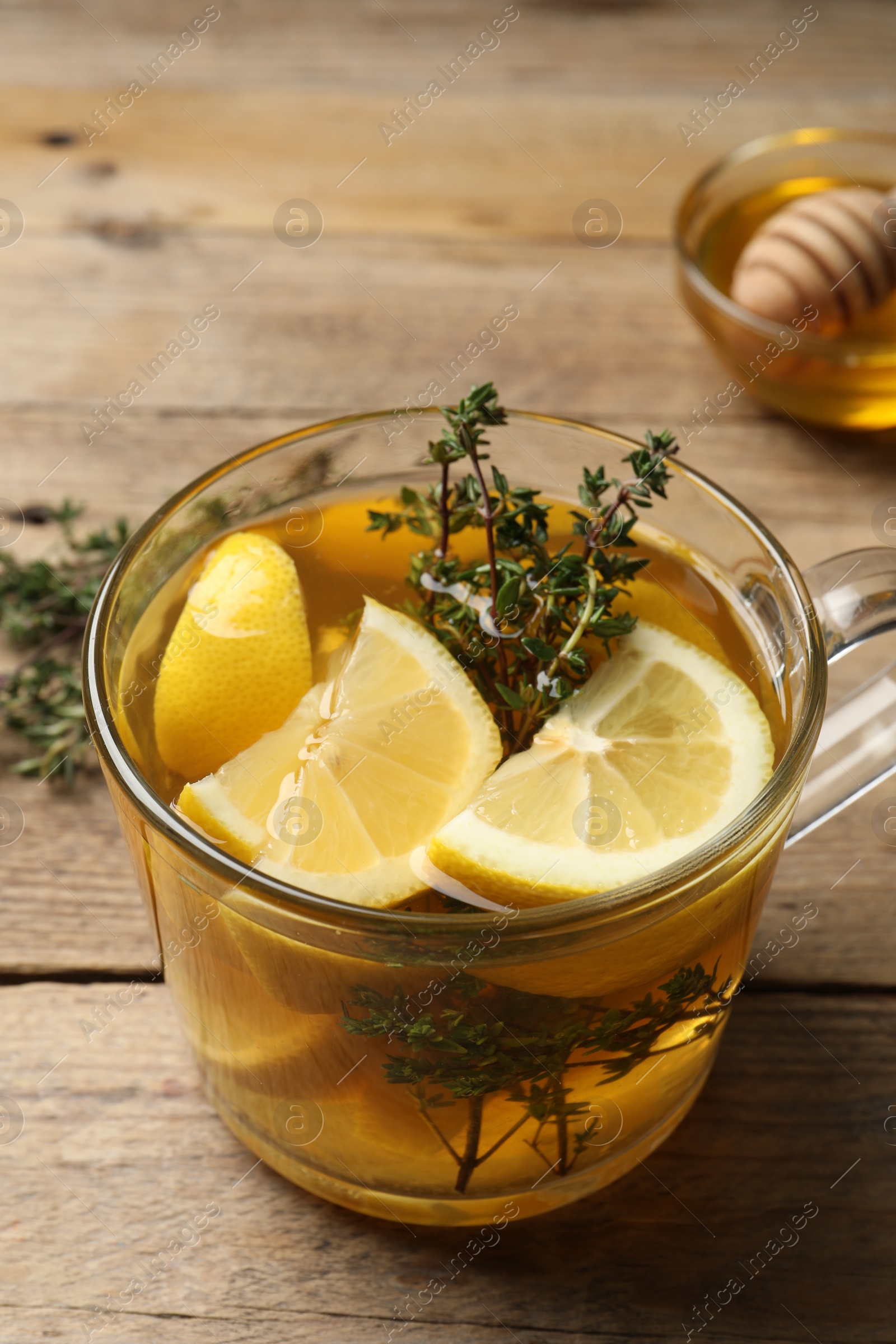 Photo of Cup of fresh thyme tea on wooden table, closeup