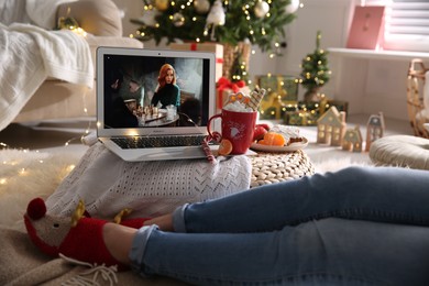 MYKOLAIV, UKRAINE - DECEMBER 25, 2020: Woman watching The Queen's Gambit series on laptop at home, closeup. Cozy winter holidays atmosphere