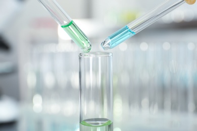 Dripping reagents into test tube with sample at laboratory. Chemical analysis