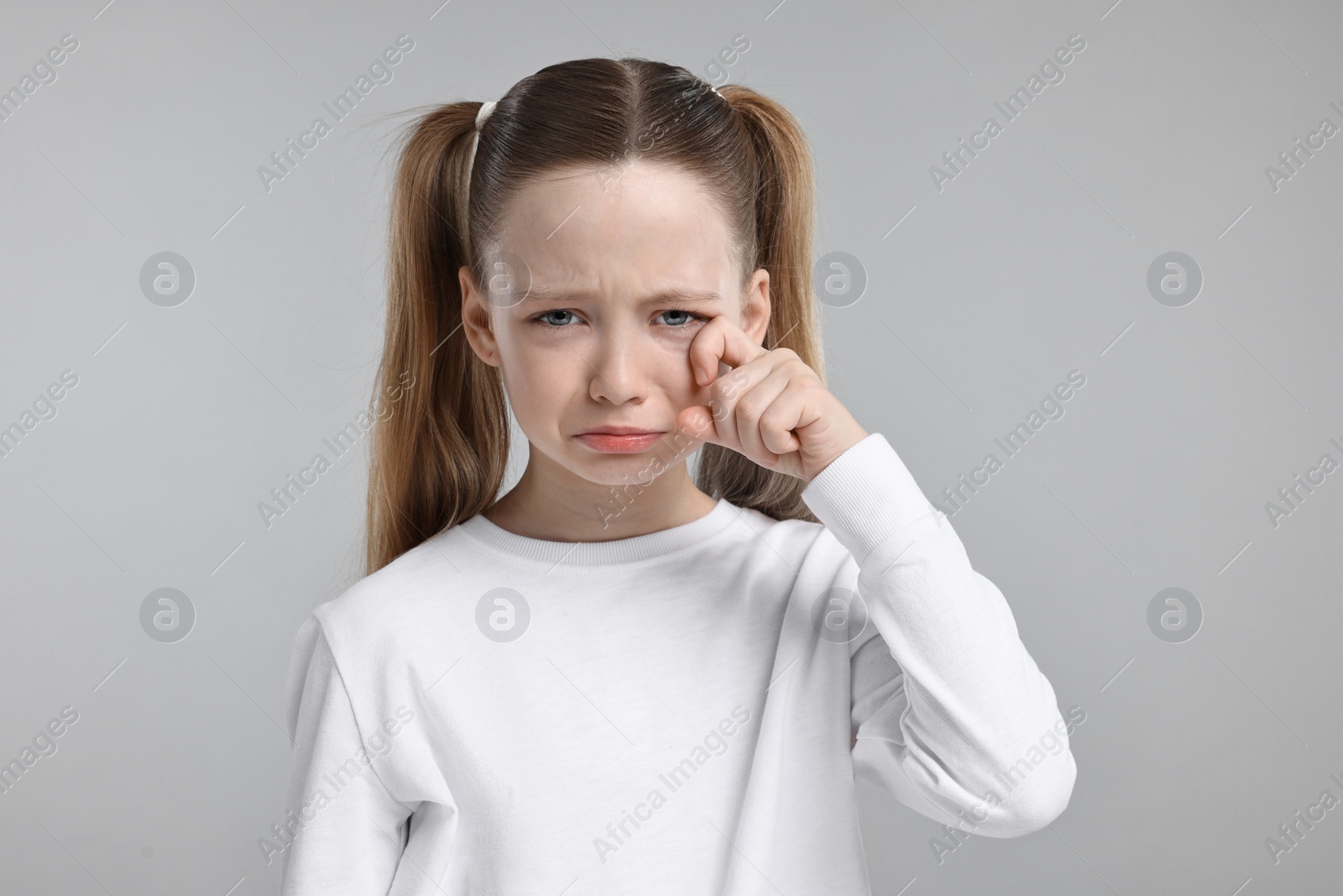 Photo of Portrait of sad girl on light grey background