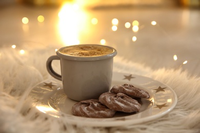 Photo of Tasty hot drink and cookies on fur
