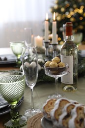 Photo of Christmas table setting with festive decor and glassware indoors