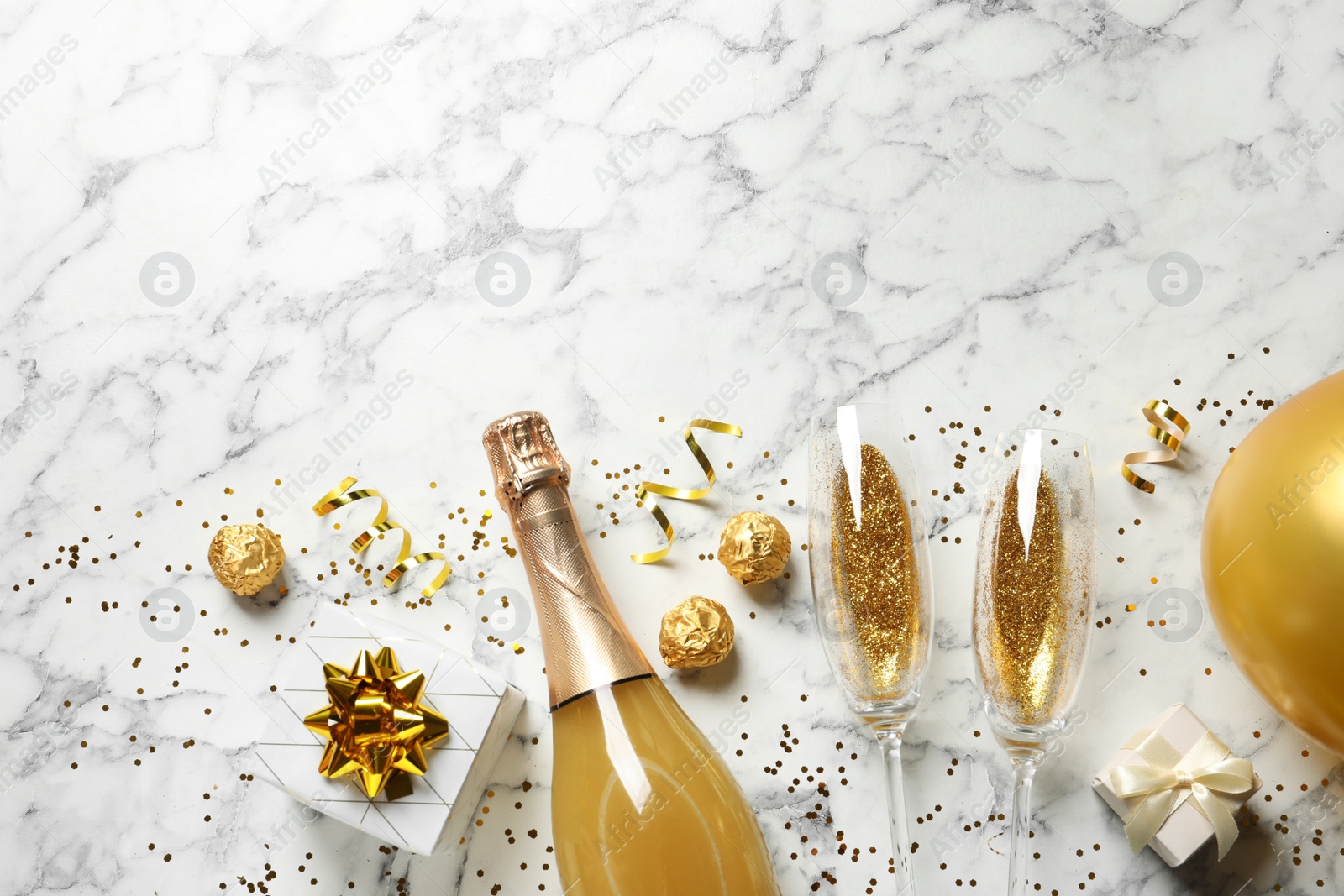 Photo of Flat lay composition with bottle of champagne for celebration on white marble background. Space for text