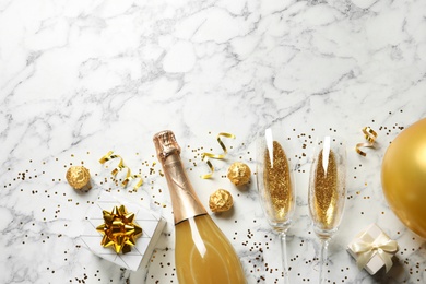 Photo of Flat lay composition with bottle of champagne for celebration on white marble background. Space for text