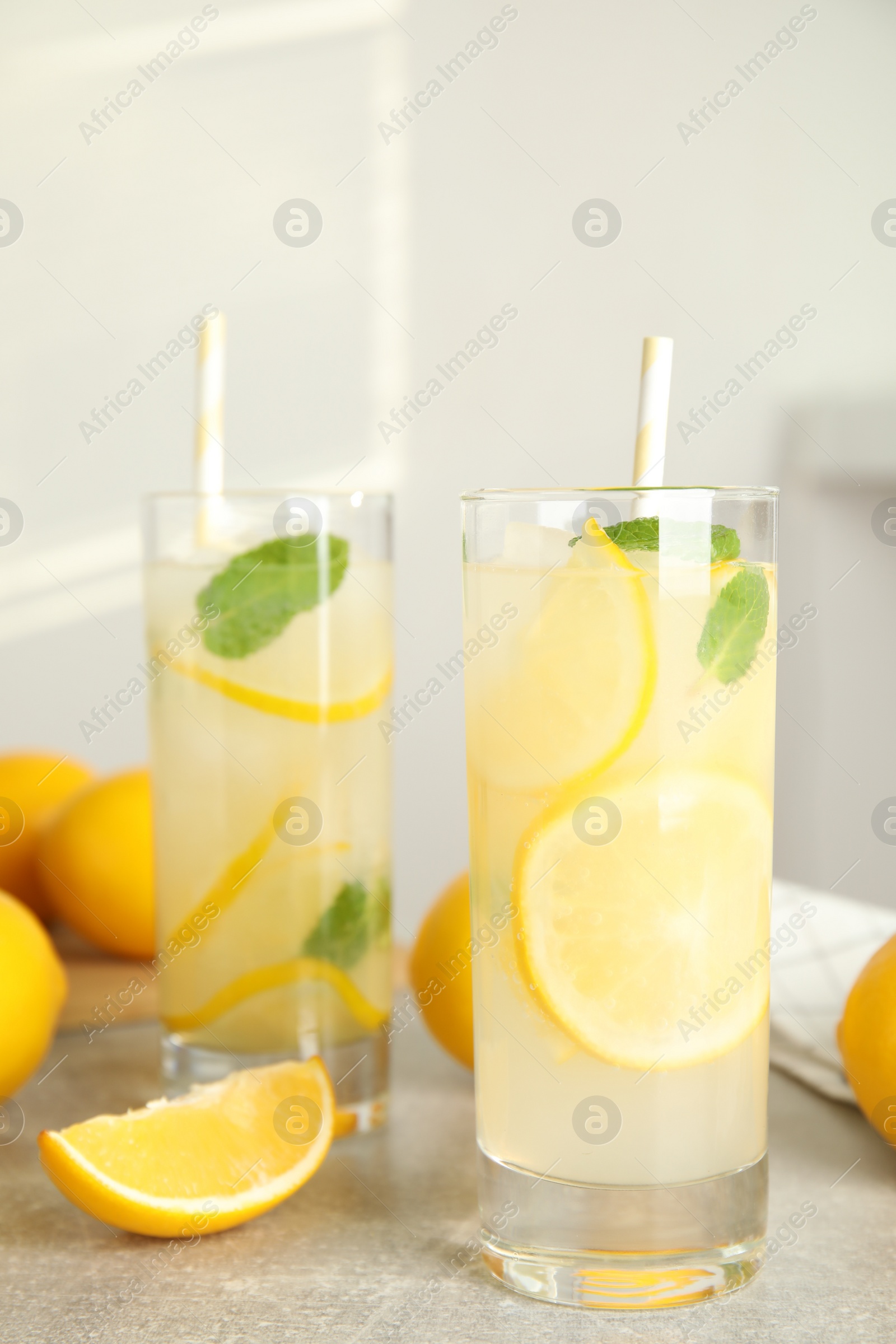 Photo of Cool freshly made lemonade and fruits on grey table