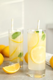 Photo of Cool freshly made lemonade and fruits on grey table