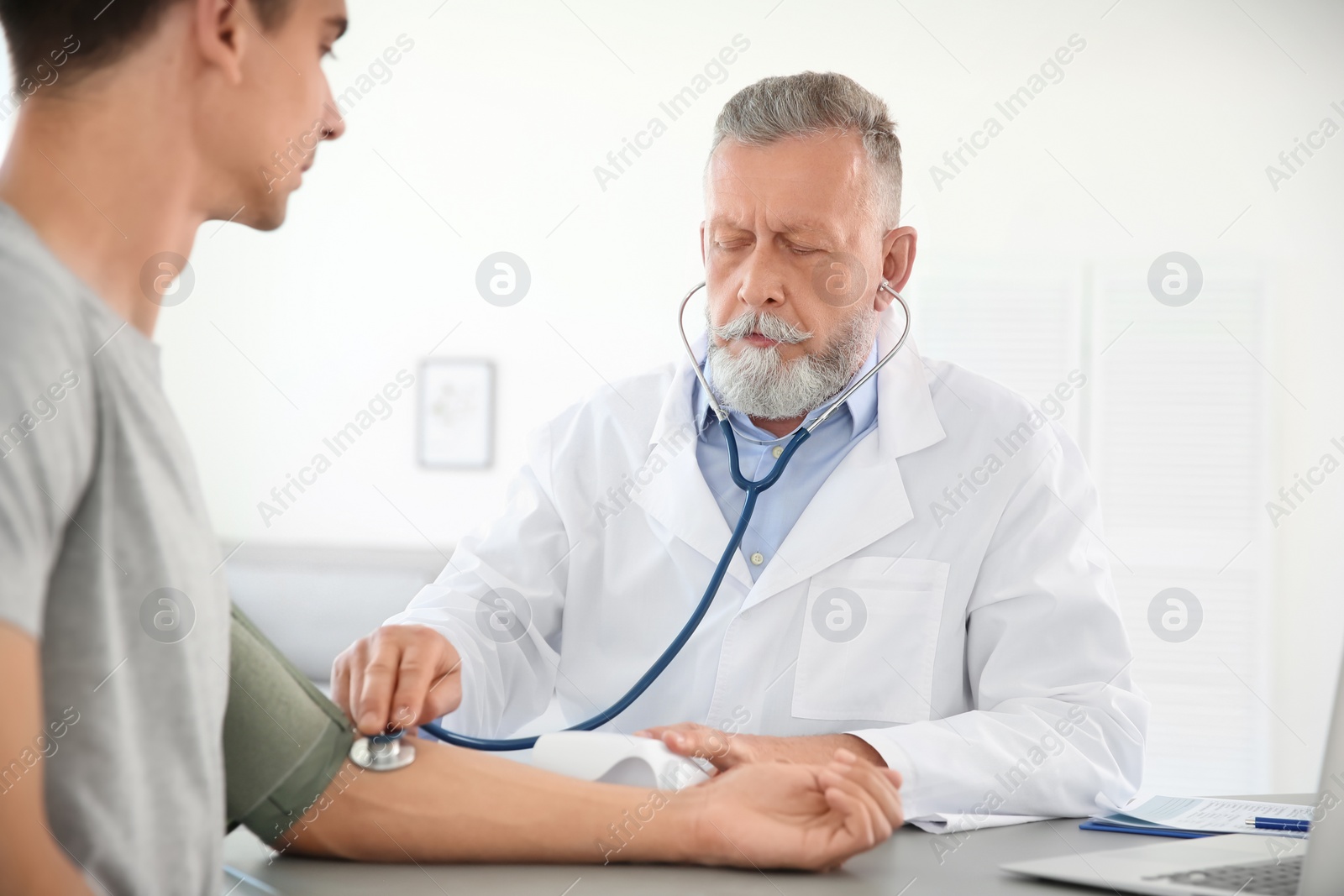 Photo of Doctor measuring patient's blood pressure in hospital