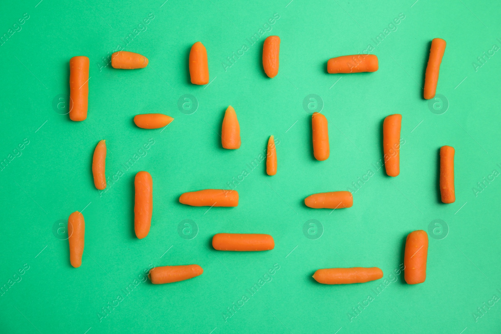 Photo of Flat lay composition with baby carrots on color background