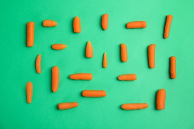 Photo of Flat lay composition with baby carrots on color background