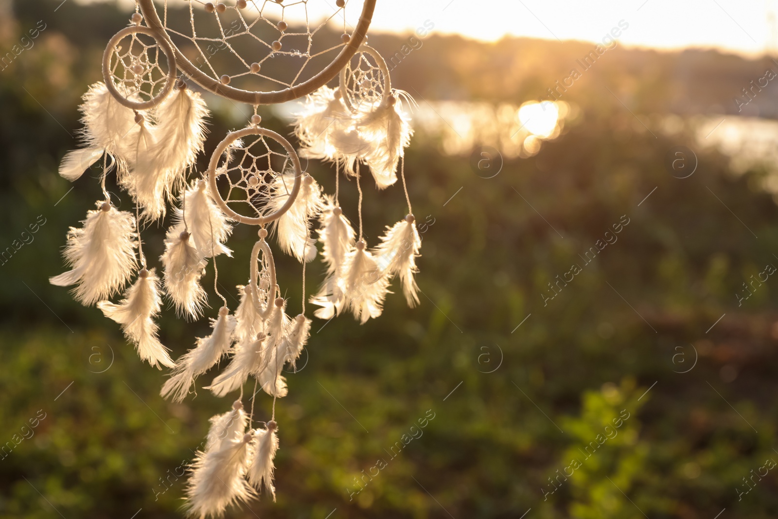 Photo of Beautiful handmade dream catcher outdoors. Space for text